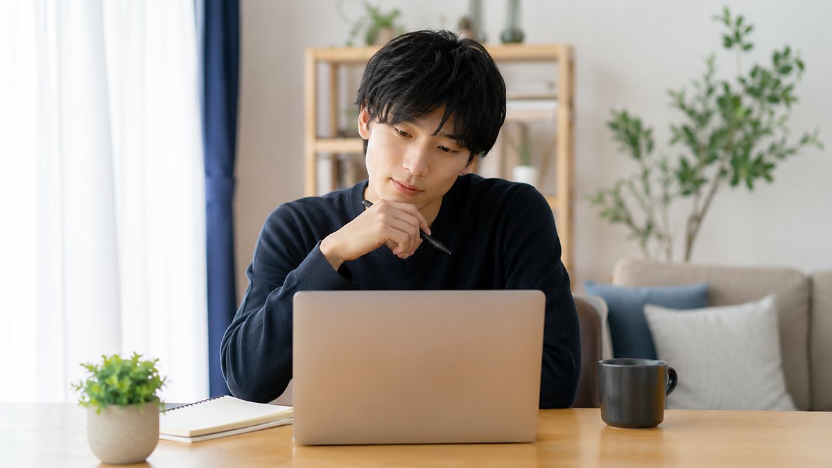 パソコンを前に考える男性（よくある質問のイメージ）